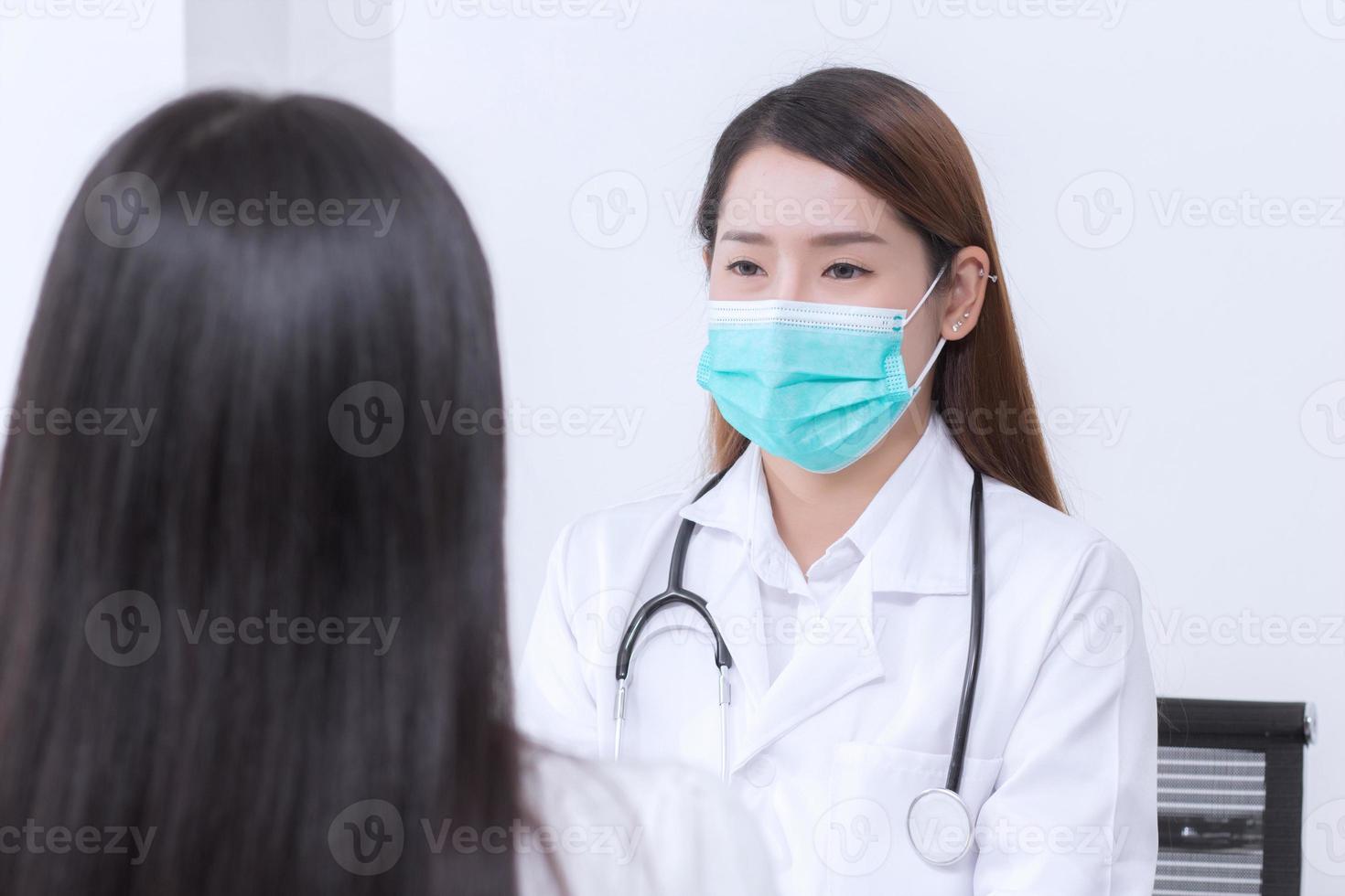 Asian woman doctor is talking with her patient to consult and check symptom which wears medical face mask always diagnostic in new normal and health care concept. photo