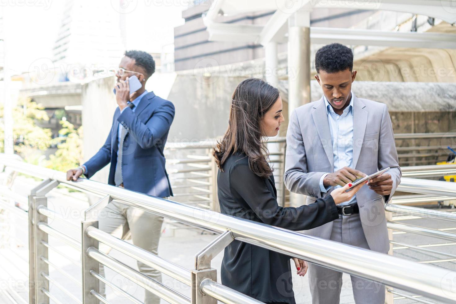 grupo de gente de negocios. gente de negocios reunida hablando y compartiendo sus ideas en la ciudad. equipo de negocios y concepto de trabajo en equipo. empresarios parados afuera en la ciudad discutiendo sobre un nuevo proyecto. foto