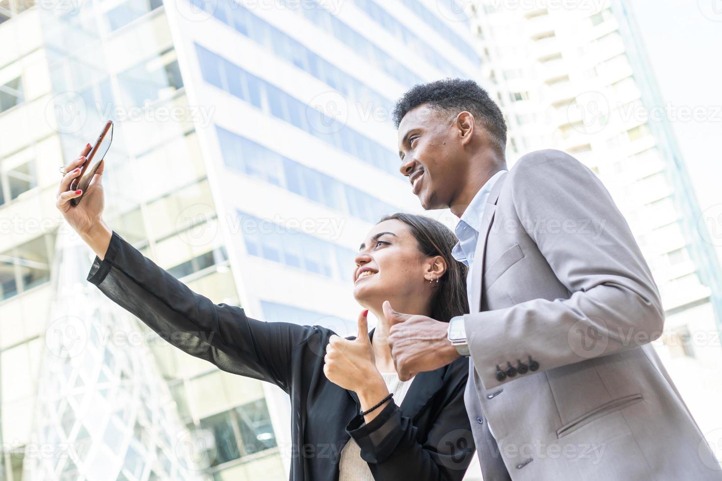 gente de negocios que usa un teléfono inteligente para selfie. gente de negocios de diversidad interracial feliz con smartphone tomando selfie o videollamada. gente de negocios exitosa tomando un selfie feliz foto