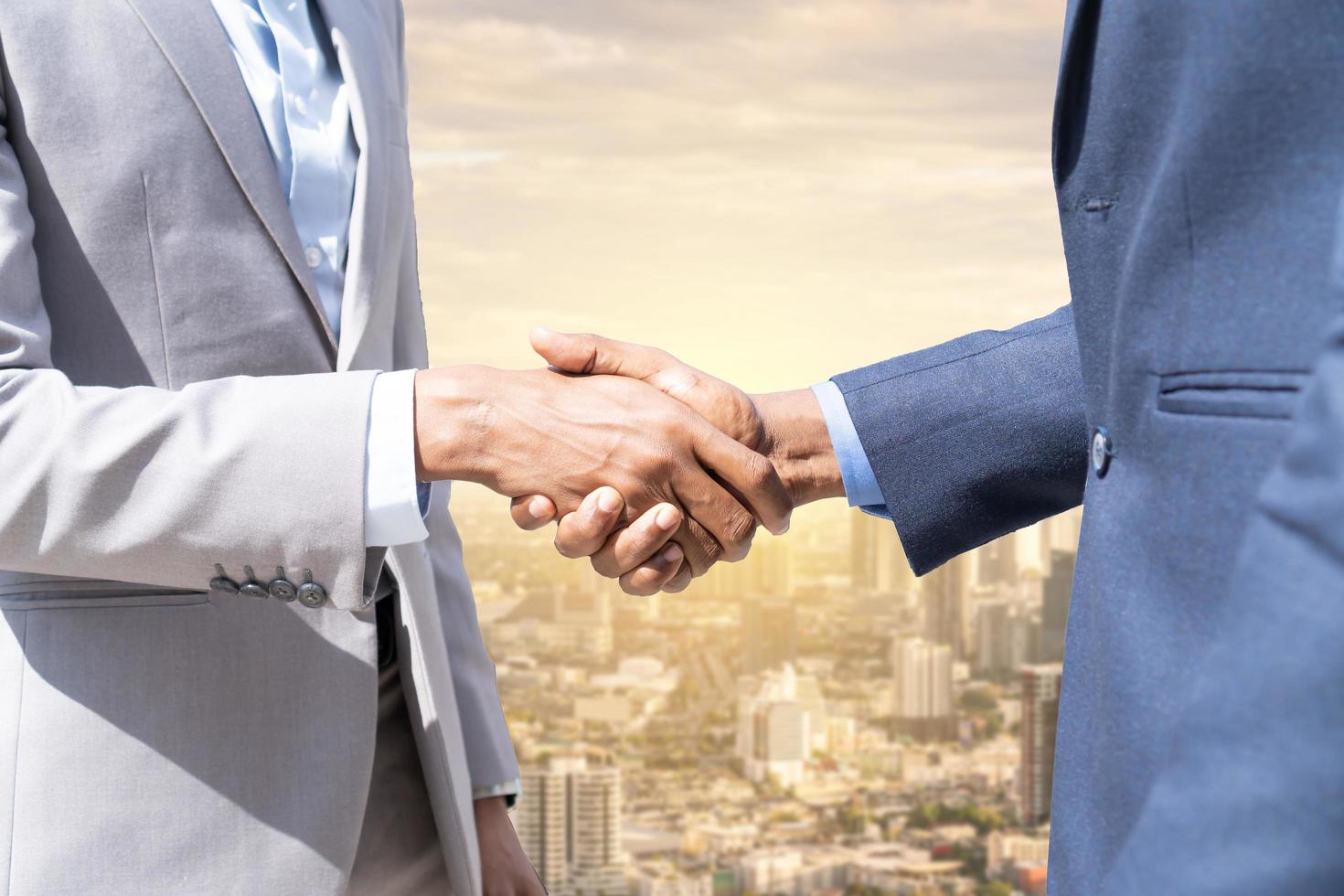 Businessmen shaking hands. Unknown businesspeople are shaking their hands after signing a contract, while standing together. photo