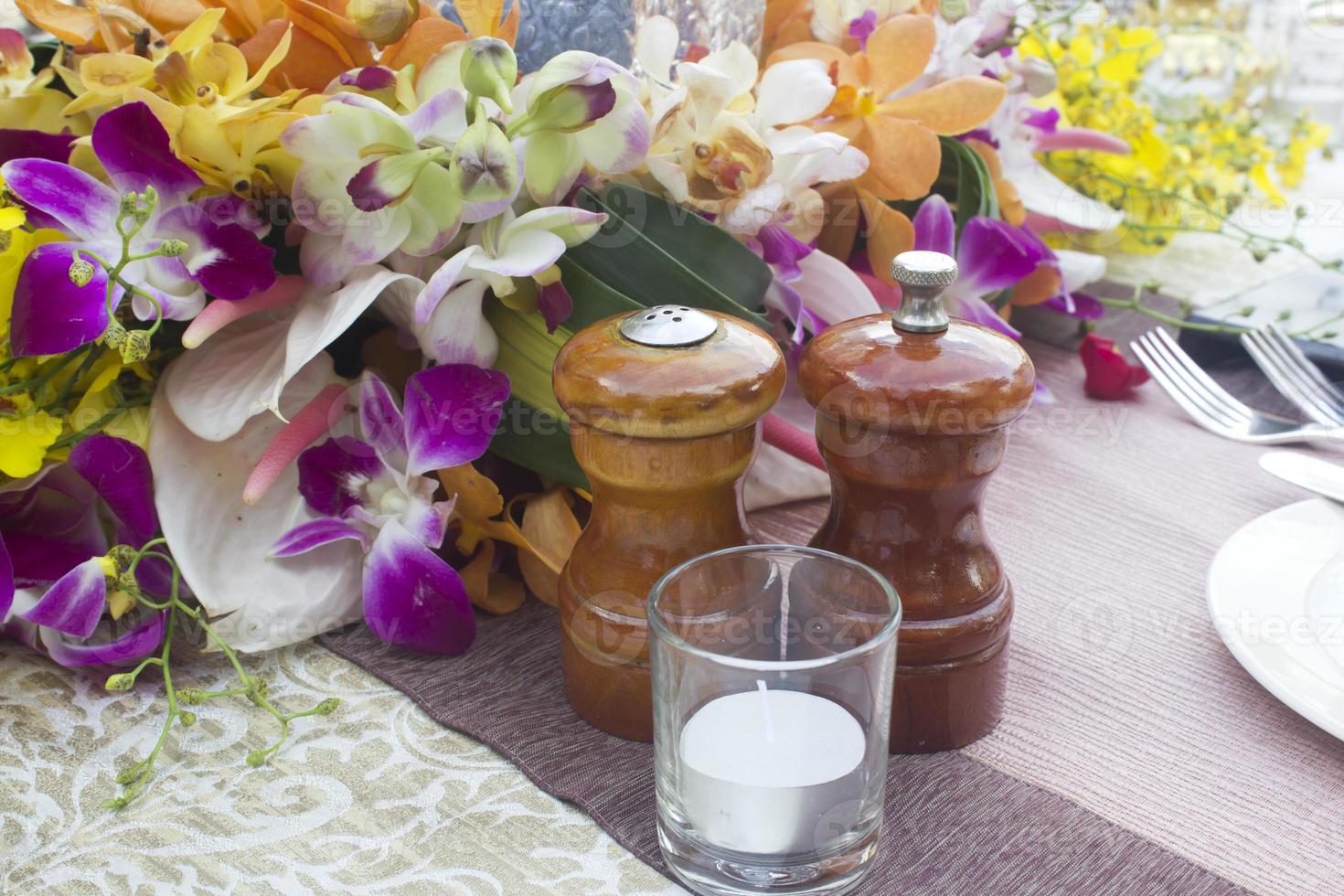 tarros, sal y pimienta en la cena de mesa con flores. foto