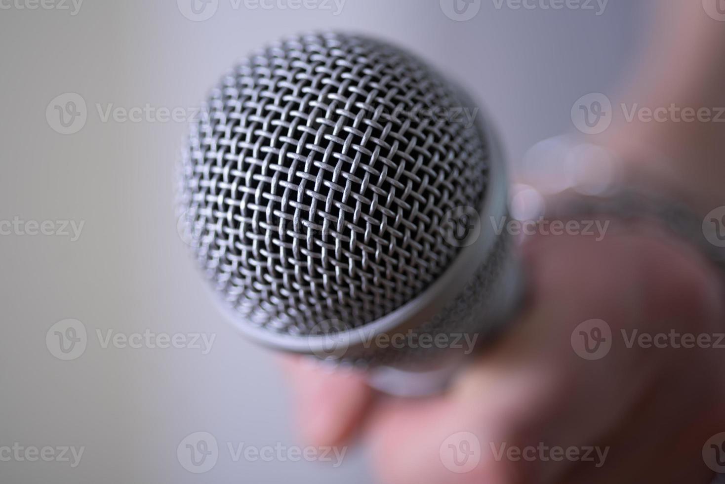 Dynamic microphone close-up on dark background, the chain on his arm. photo