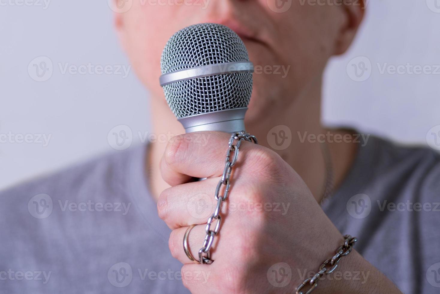 A man speaks into a microphone in close-up. photo