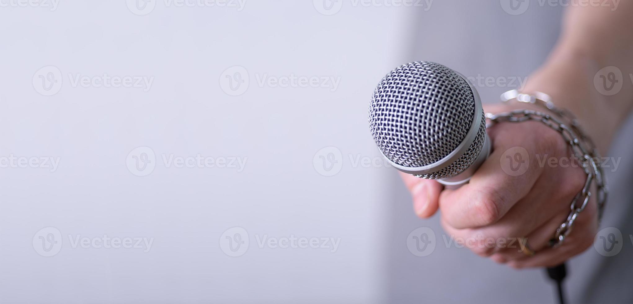 A man holds a microphone in his hand with room to copy. photo