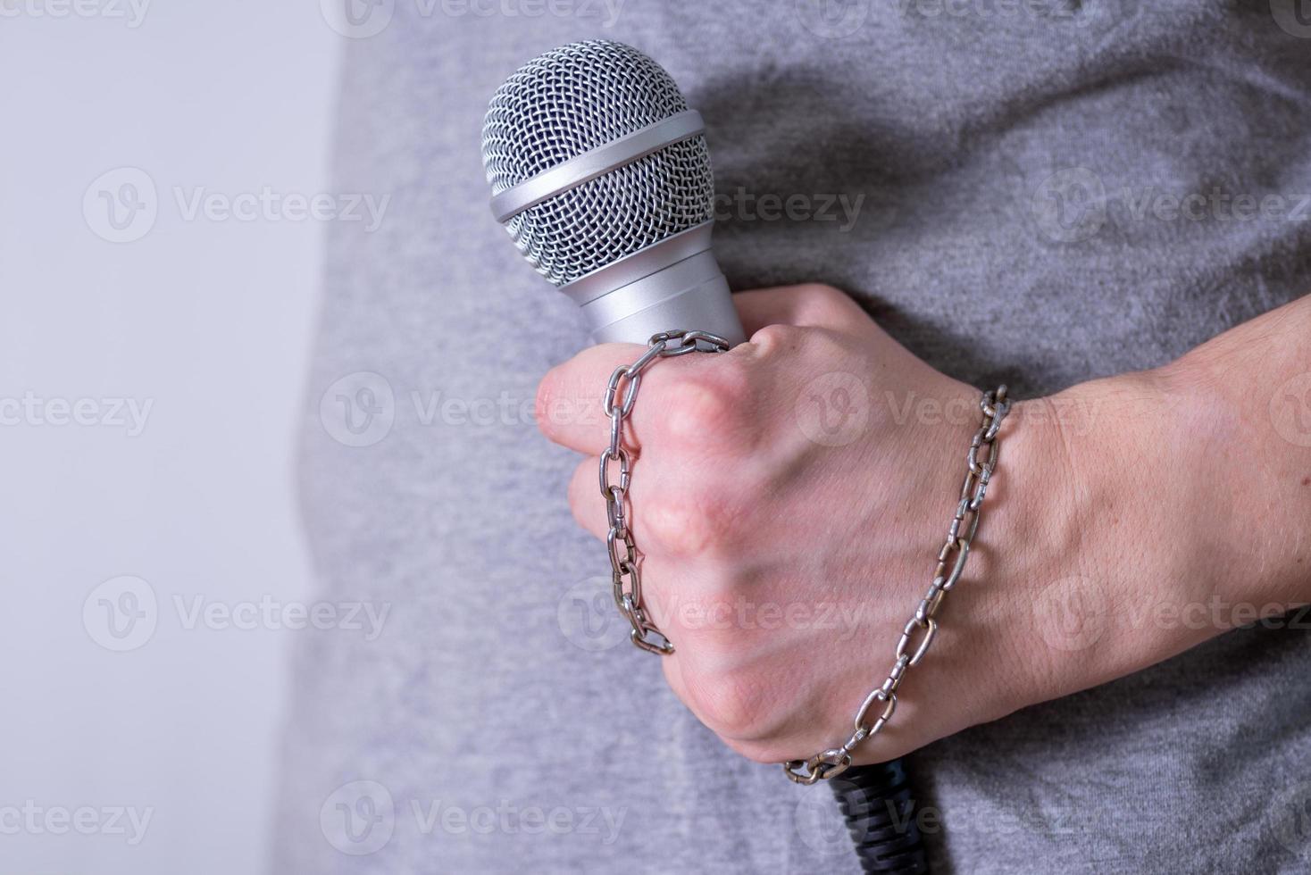 primer plano de micrófono dinámico sobre fondo oscuro, la cadena en su brazo. foto