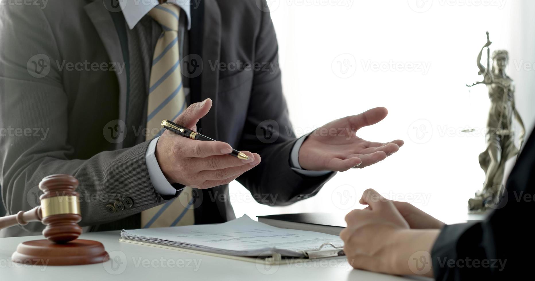 Business woman and lawyers discussing contract papers with brass scale on wooden desk in office. Law, legal services, advice, Justice concept. photo