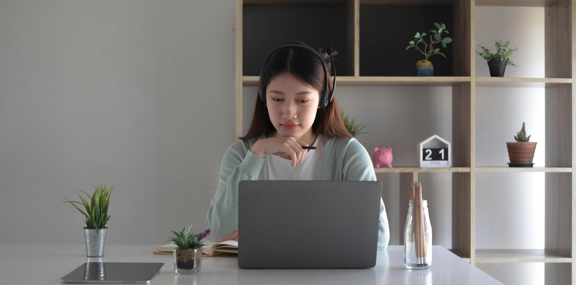 Curious Asian students while studying online on the internet and laptop video conferencing teachers at home. photo