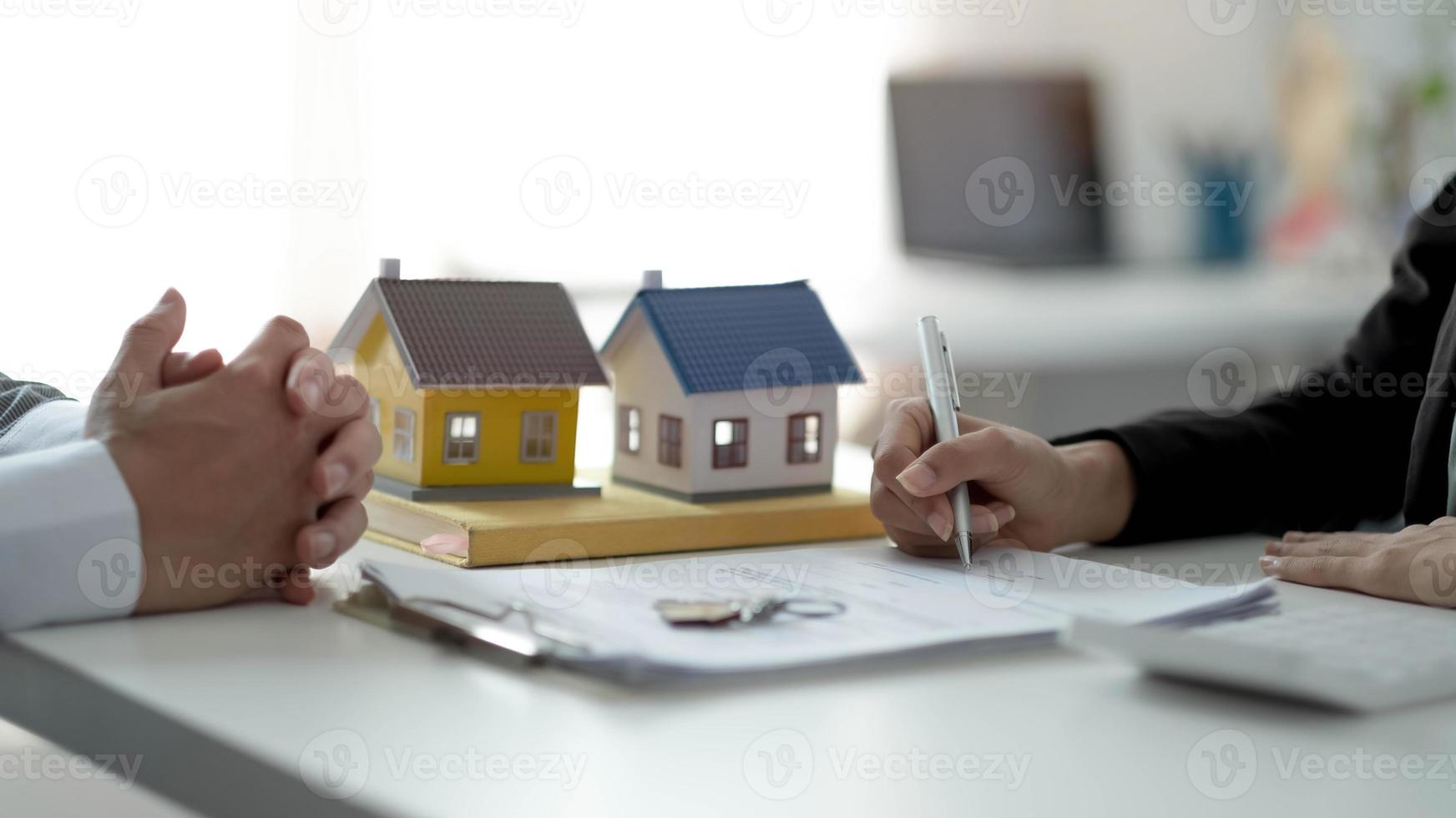 Real estate agent or sales manager has proposed terms and conditions to customers who sign house purchase agreements with insurance, Agreement to sign the purchase contract concept. photo