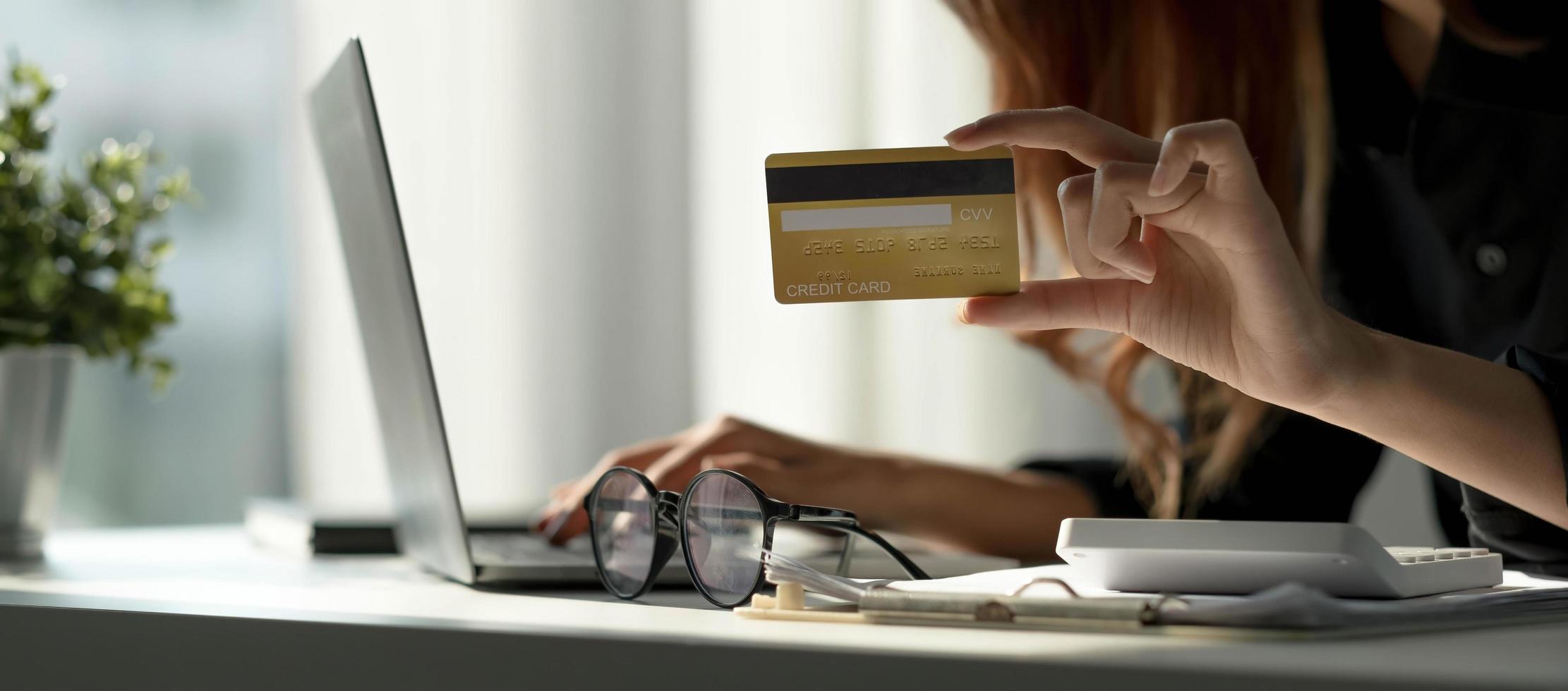 Asian woman checking online order details on computer and use the credit card information entered on the computer. photo