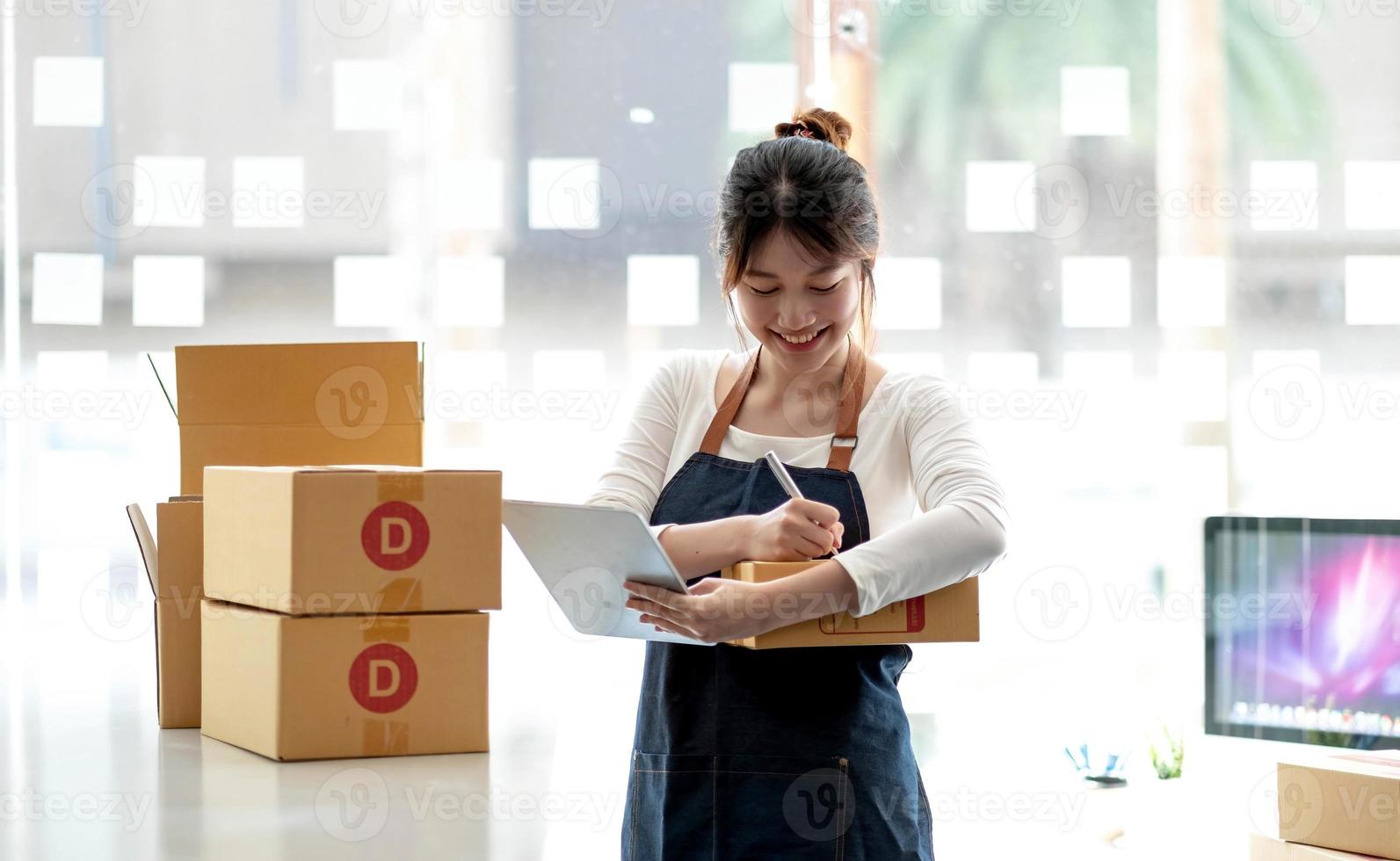 Portrait of Starting small businesses SME owners female entrepreneurs working on receipt box and check online orders to prepare to pack the boxes, sell to customers, sme business ideas online. photo