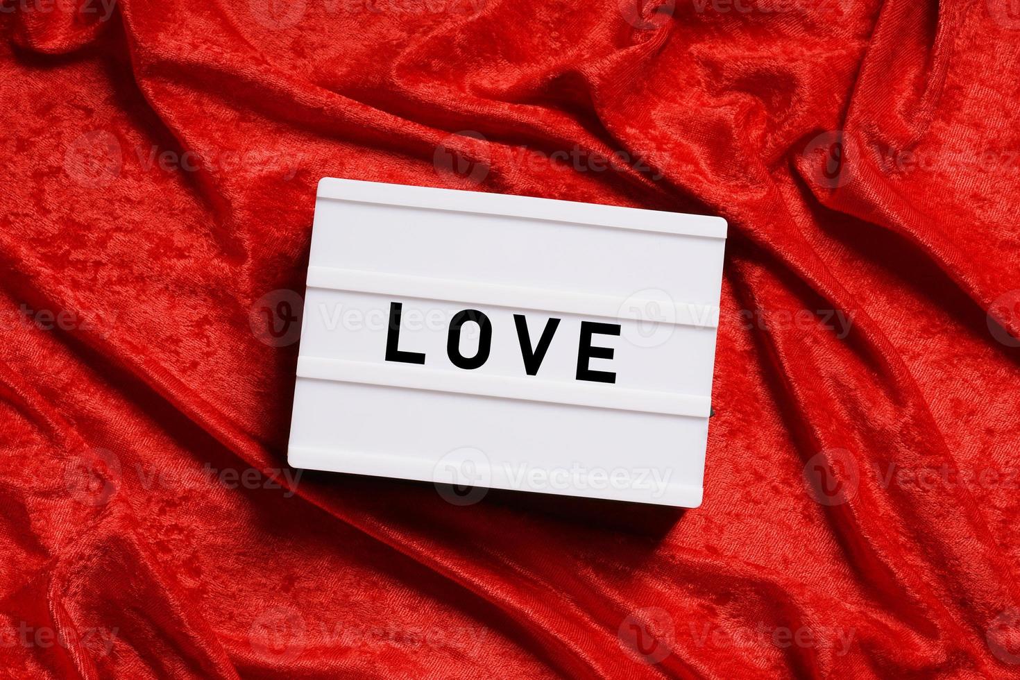 love word lightbox on red velvet background photo