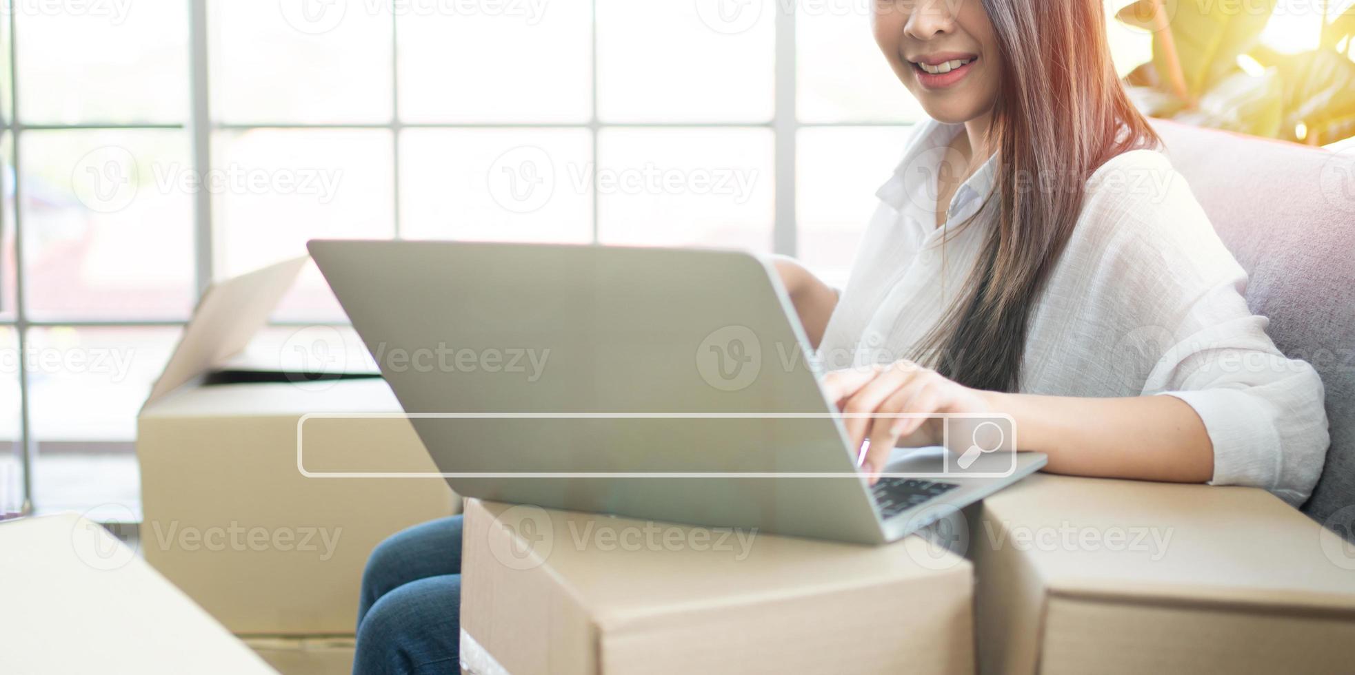 Happy young Asian woman entrepreneur, Smile for sales success after checking order from online shopping store in laptop at home office, Concept of merchant business online and eCommerce photo