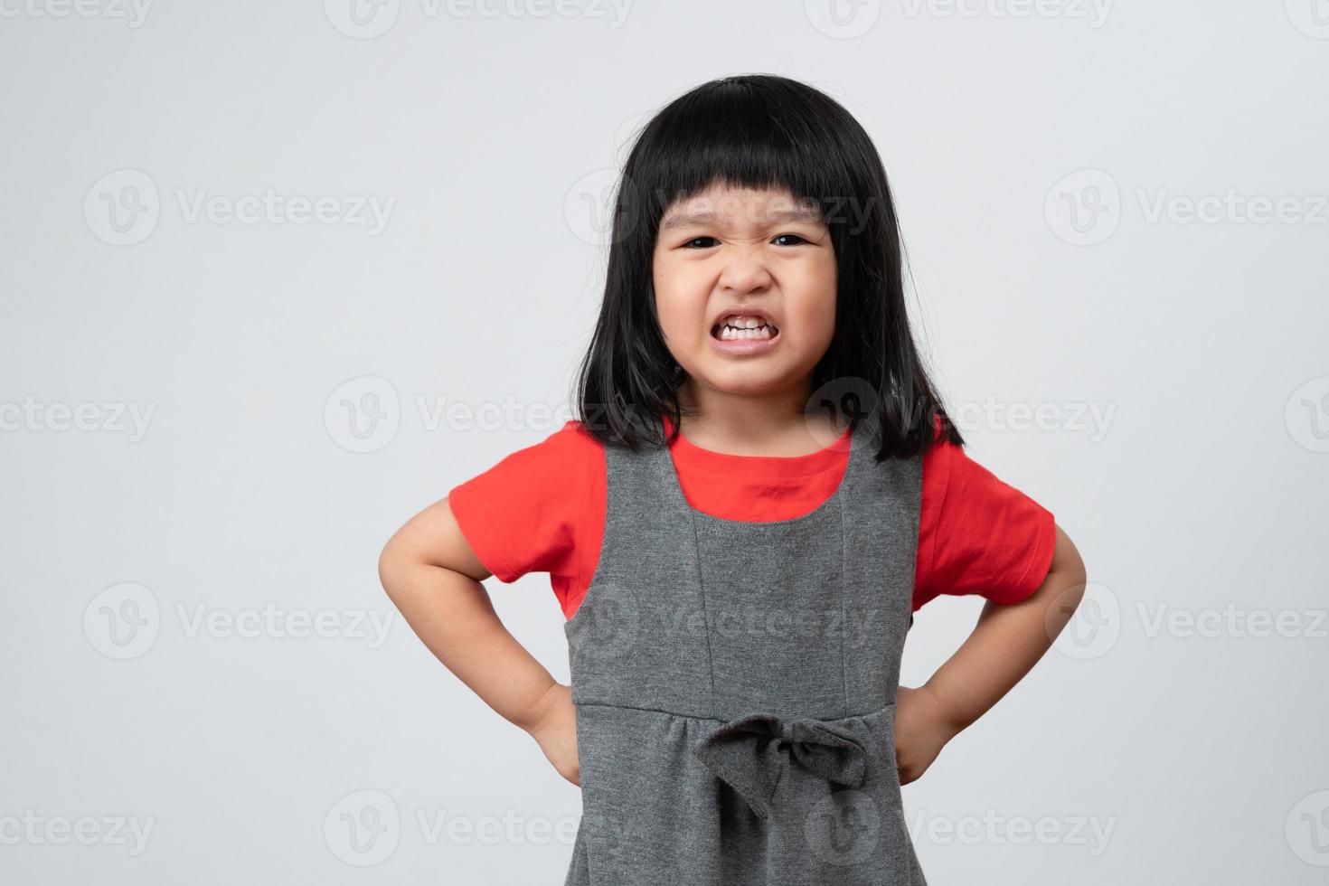 Portrait of Asian angry and sad little girl on white isolated background, The emotion of a child when tantrum and mad, expression grumpy emotion. Kid emotional control concept photo