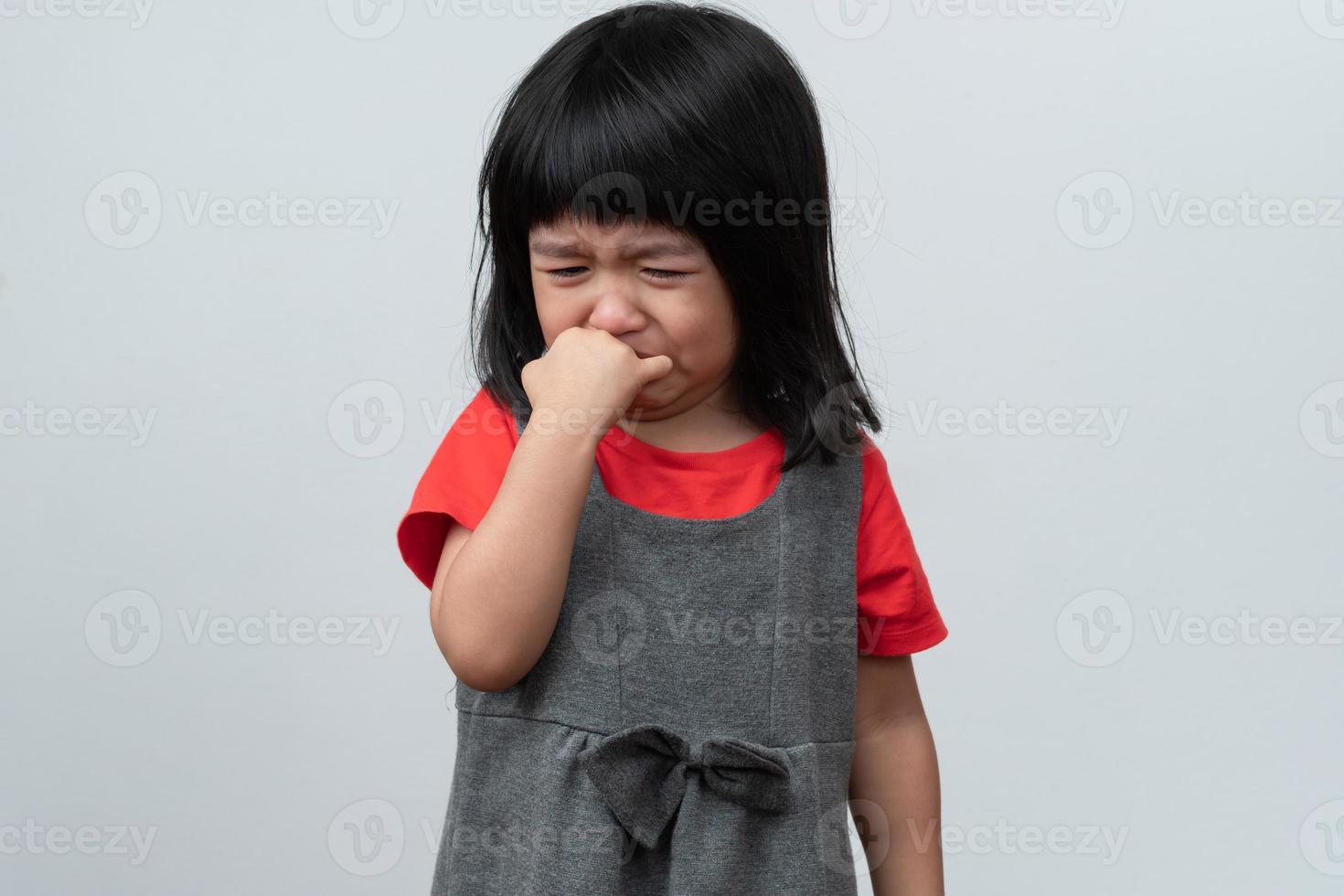 Portrait of Asian angry, sad and cry little girl on white isolated background, The emotion of a child when tantrum and mad, expression grumpy emotion. Kid emotional control concept photo