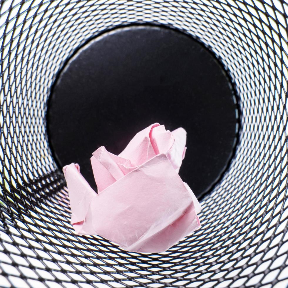 Inside a small black basket made of round iron fell down. It is used to put the trash, documents that are not working and are overflowing to the outside. photo