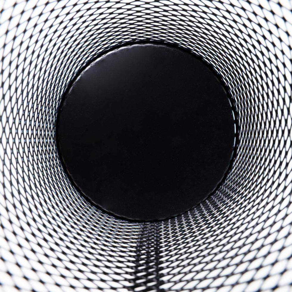 Inside corner, a small black basket made of round steel as a grid. It is used to put the trash, documents that are not working and are overflowing to the outside. photo