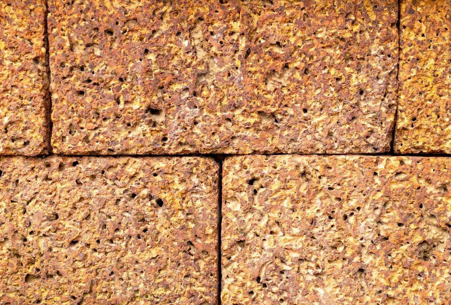 textura de piedra de ladrillo hay muchos agujeros debido al deterioro debido a las condiciones climáticas y la edad. puede ser fondo foto