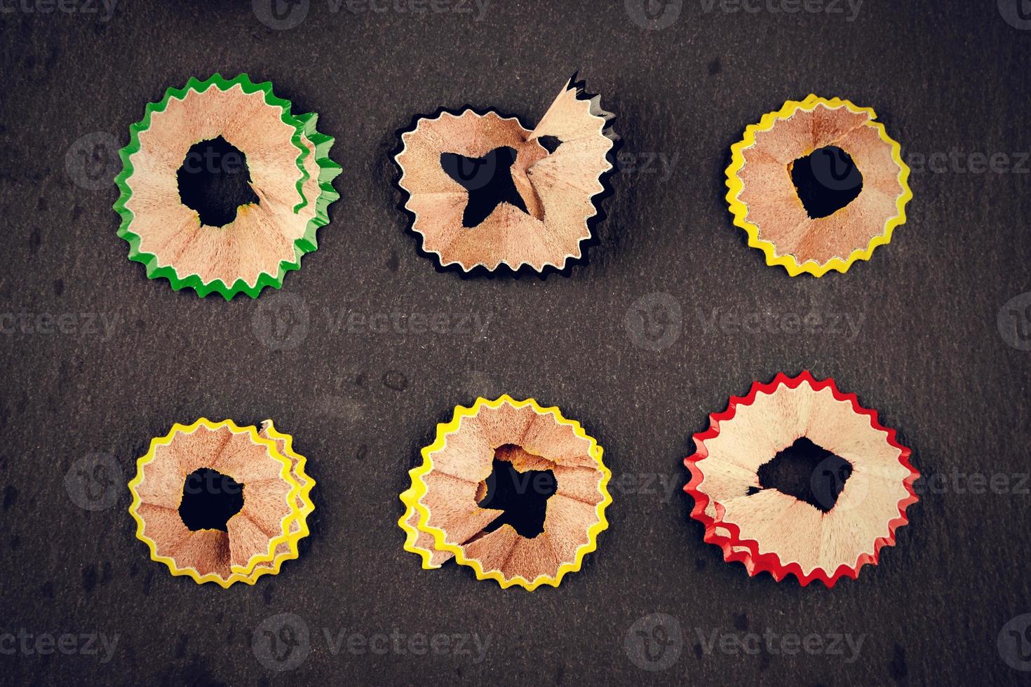 Color shavings pencils on black background viewed from above. Vintage style. Horizontal image. photo