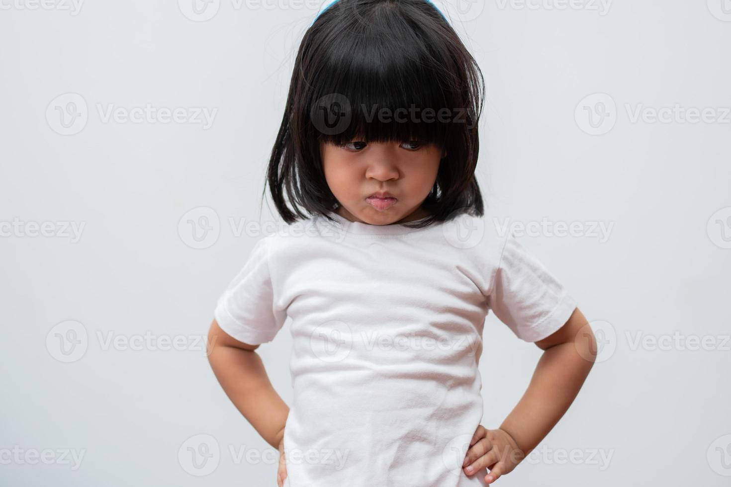 Portrait of Asian angry and sad little girl on white isolated background, The emotion of a child when tantrum and mad, expression grumpy emotion. Kid emotional control concept photo