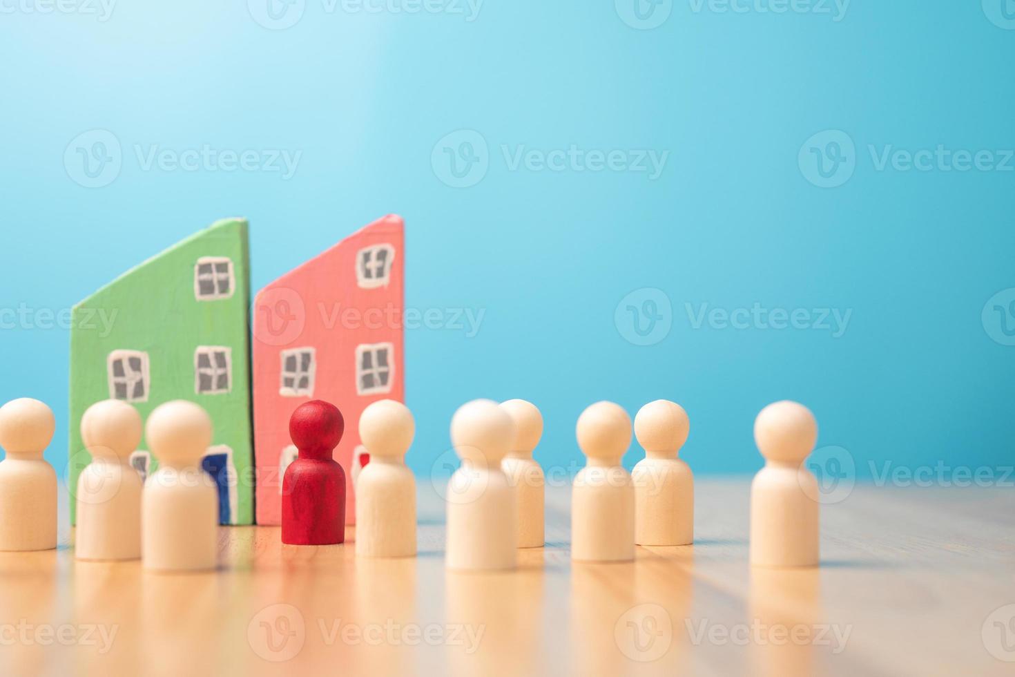 A wooden figure standing with a team to influence and empowerment. Concept of leadership, successful competition winner and Leader with influence and Social distancing for a new normal lifestyle photo