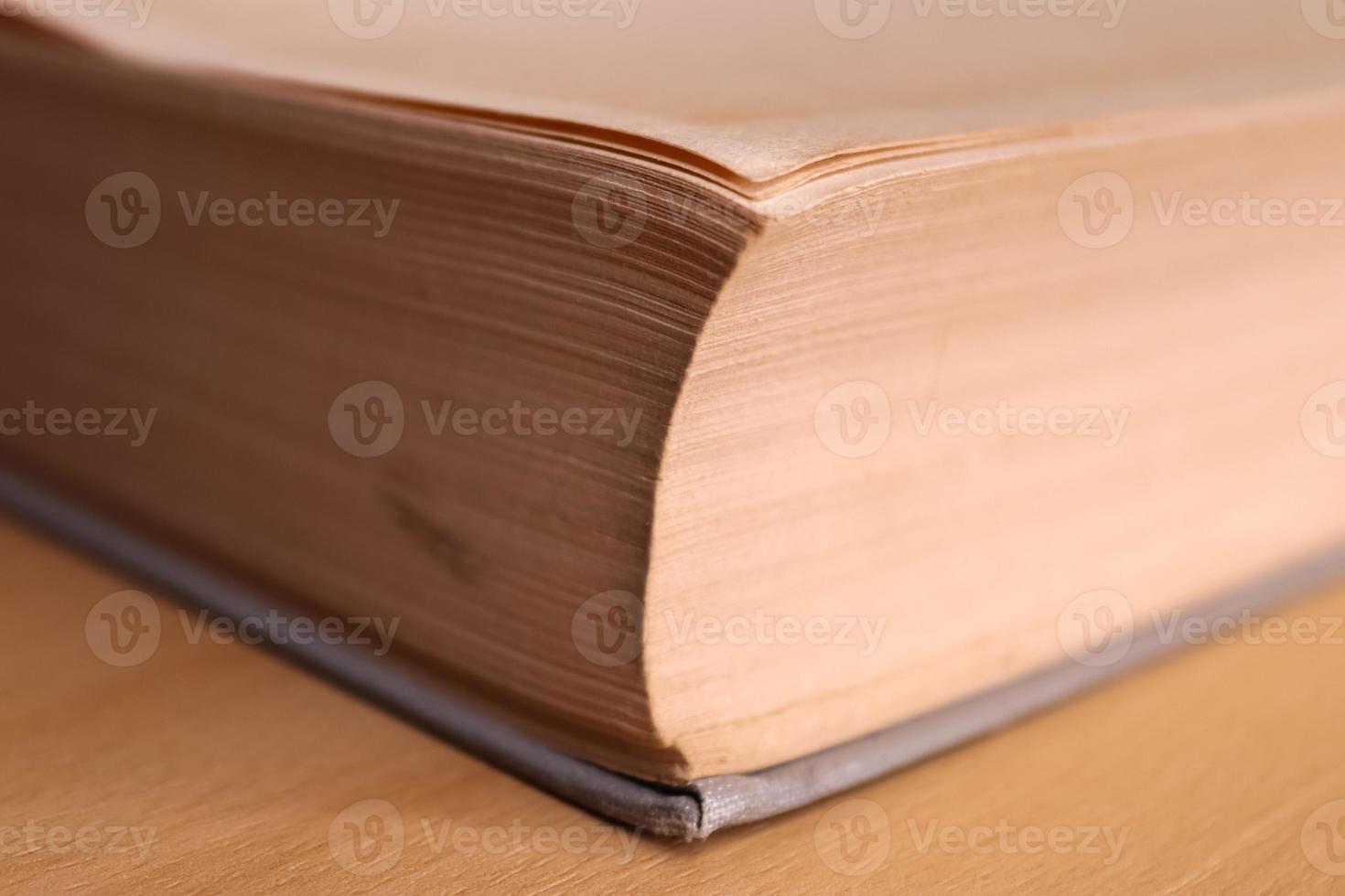 Selective focus view of an old thick german mathematics book with a male hand searching in it. photo