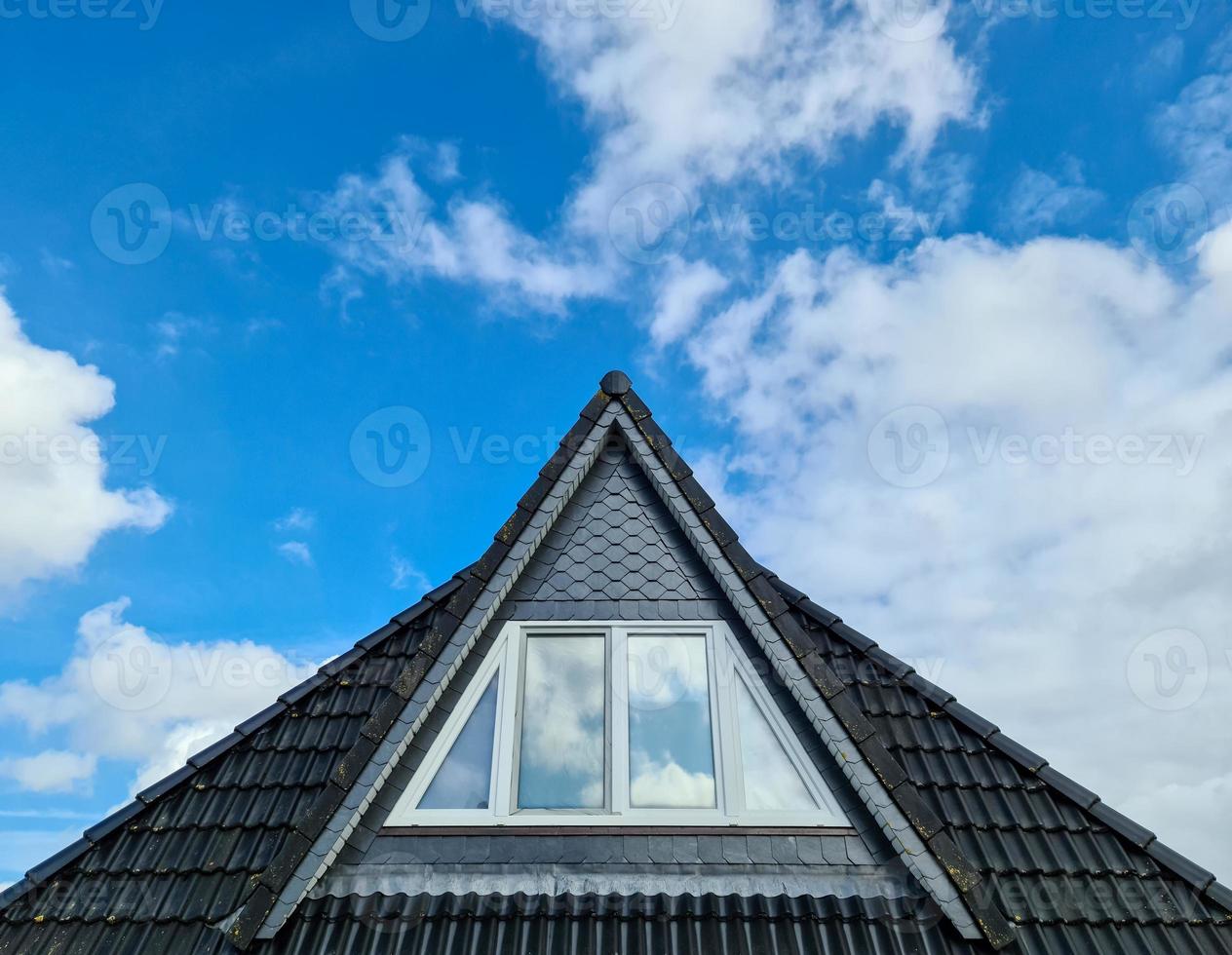 Open roof window in velux style with black roof tiles. photo