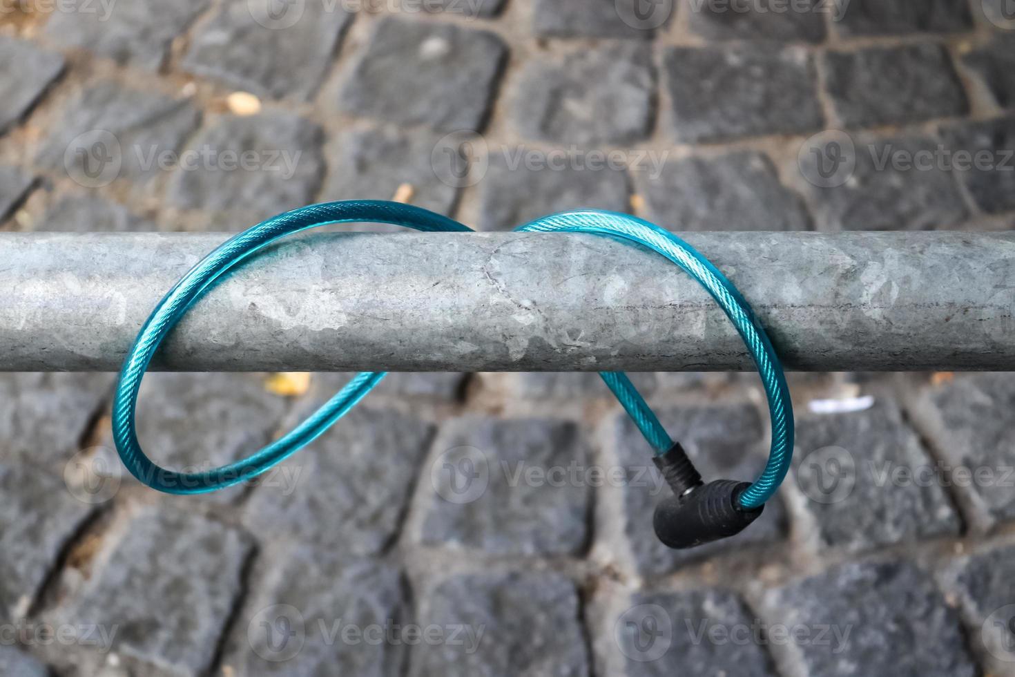 Abandoned bike lock left at a metallic fence from a stolen bike photo