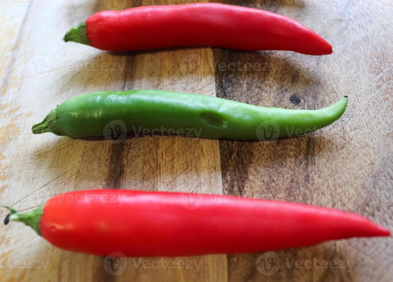 Top and perspective view of chili pepper and steel knife on a wooden cutting board with an isolated background photo