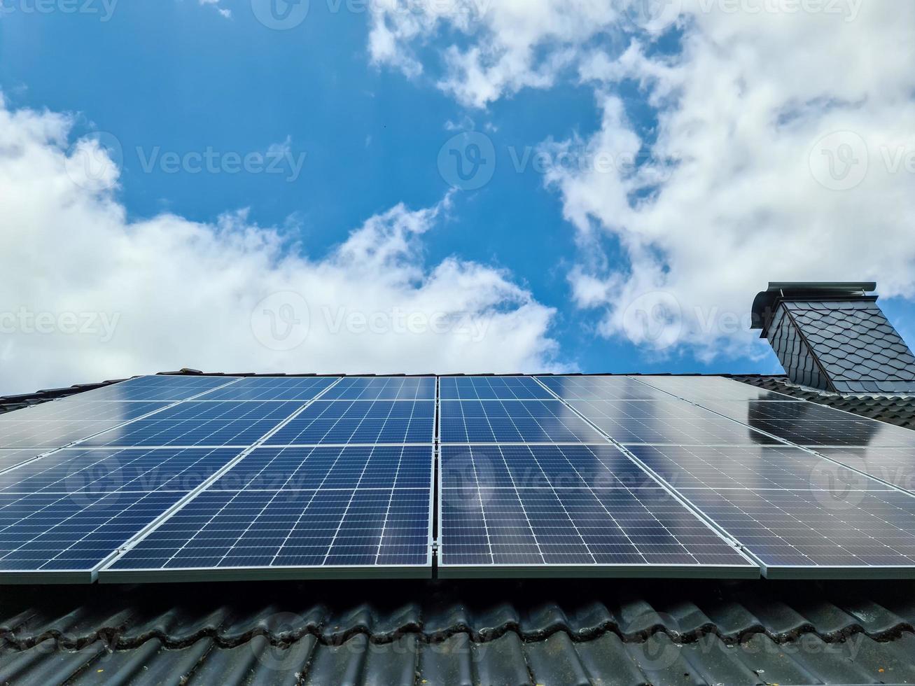 Solar panels producing clean energy on a roof of a residential house photo