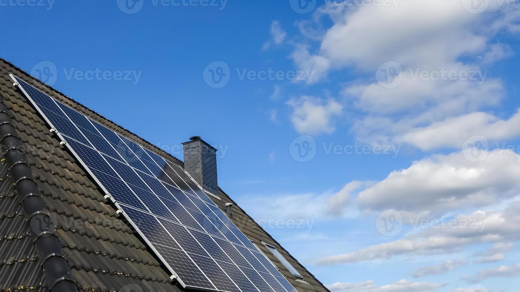 paneles solares que producen energía limpia en el techo de una casa residencial foto