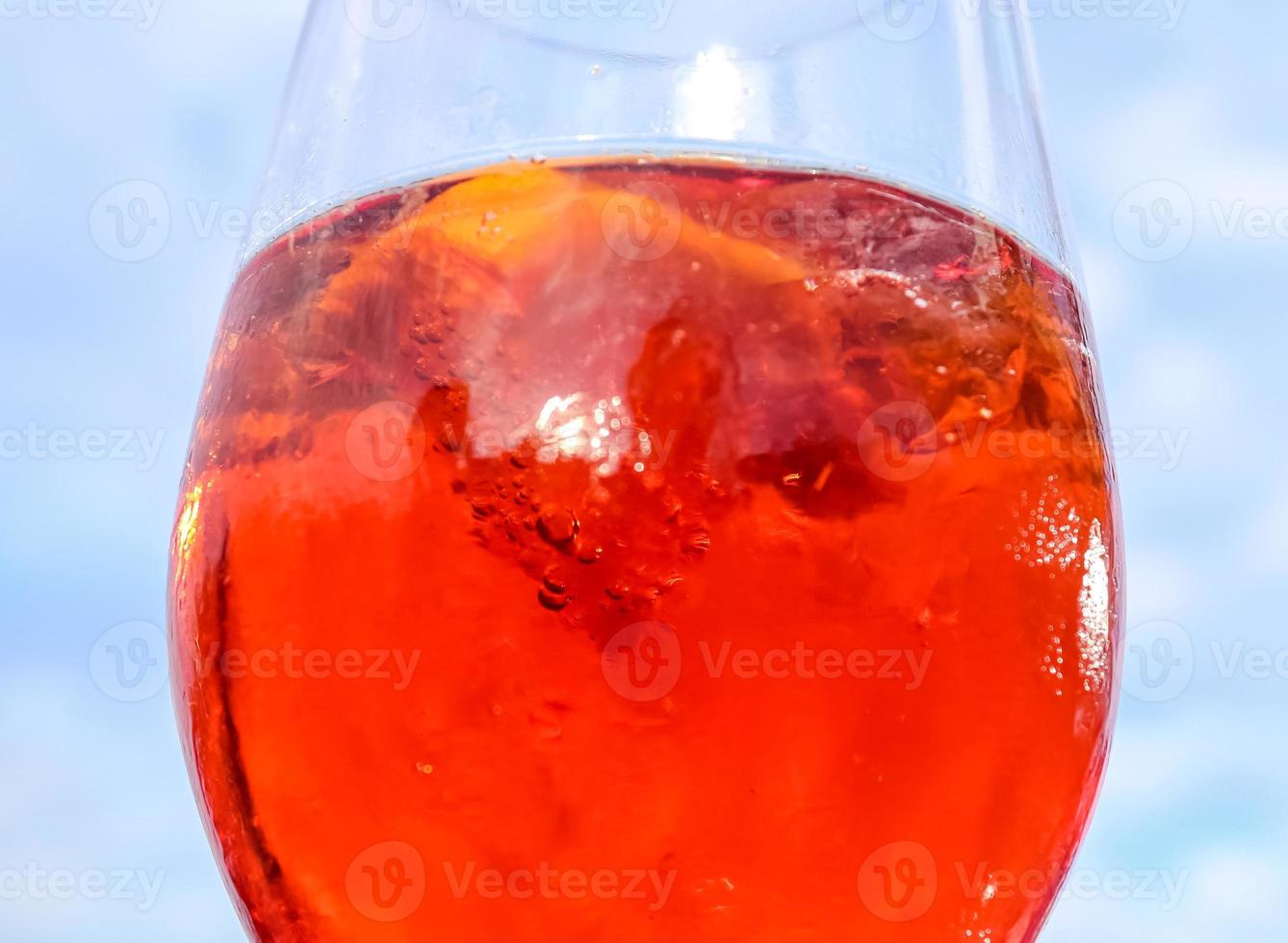 refrescantes cócteles de verano naranja con cola y hielo sobre un fondo de cielo azul. vista de cerca foto