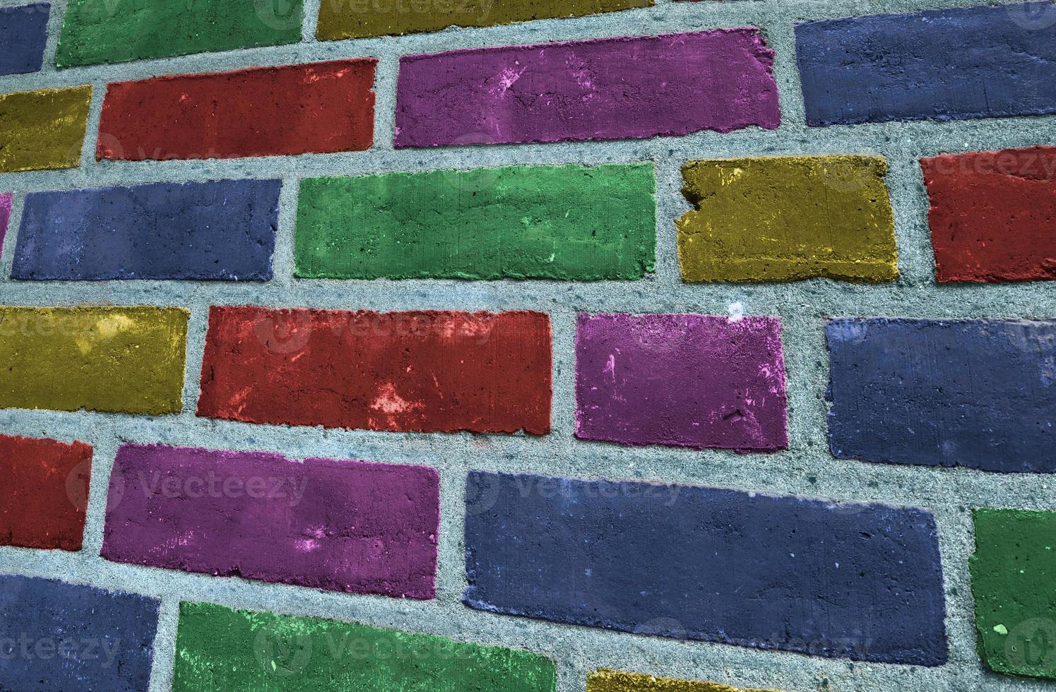 Beautiful rainbow colored bricks on an old and weathered wall texture photo