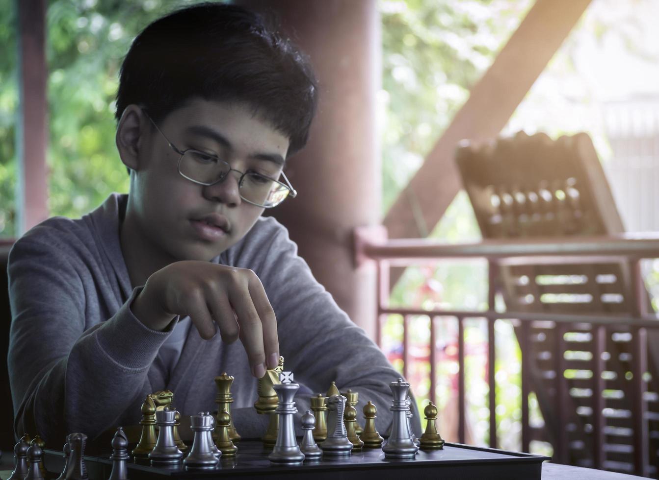 Concentrated serious boy developing chess gambit, strategy ,playing board game to winner. Learning, tactics and analysis concept. photo