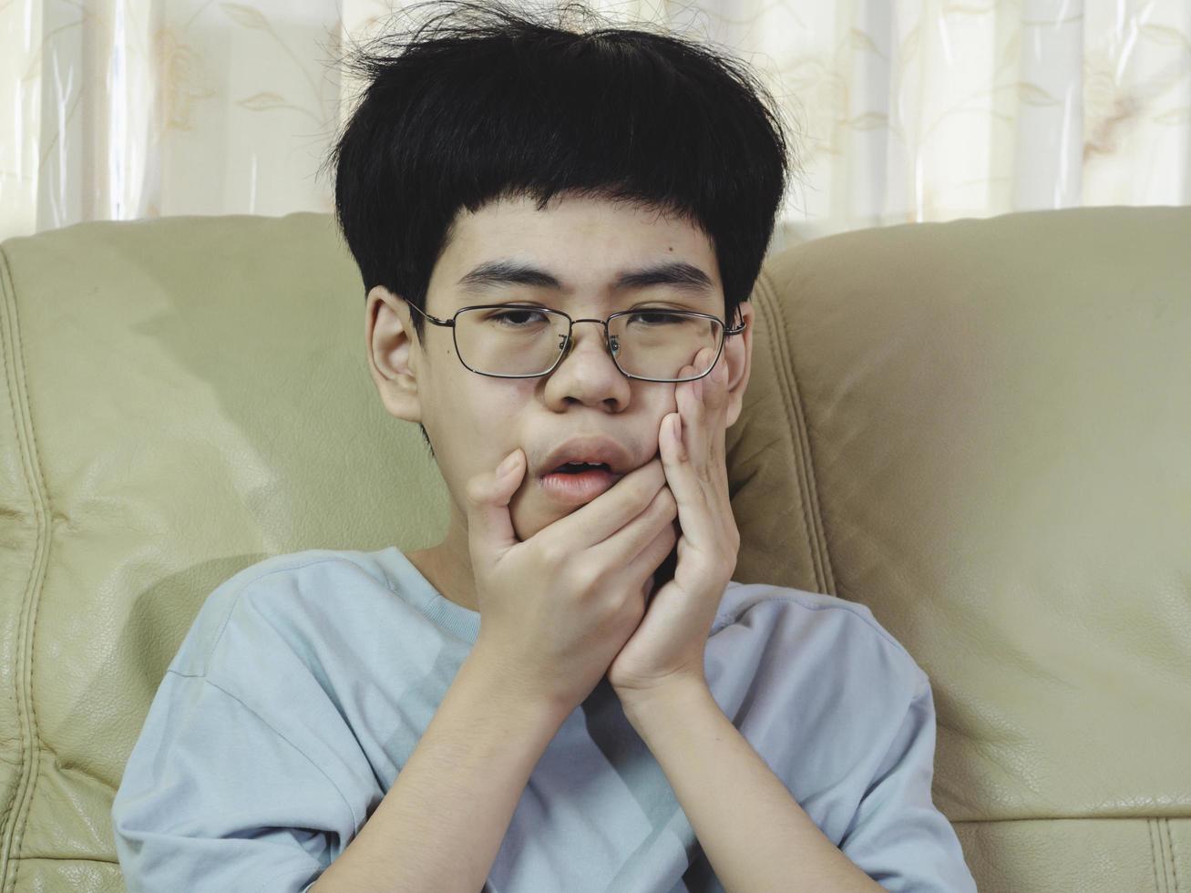 Little asia boy suffer from toothache. He sad with tooth pain, dental disease, kid suffering from dental problem. Plan to appointment dentist. photo