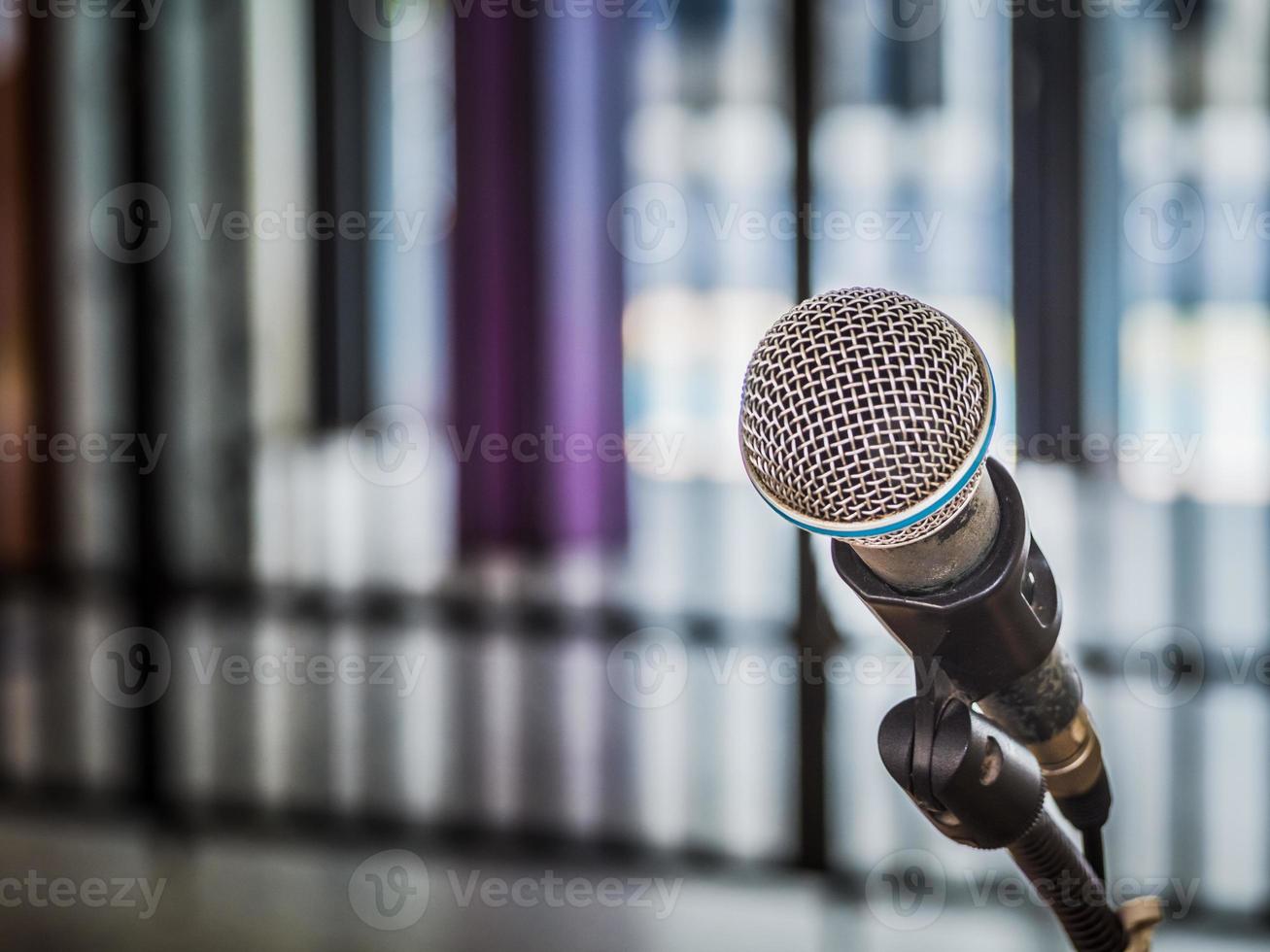 primer plano del micrófono sobre un fondo borroso abstracto para hablar en la sala de seminarios o en la sala de conferencias de comunicación y oratoria, concepto de fondo. foto