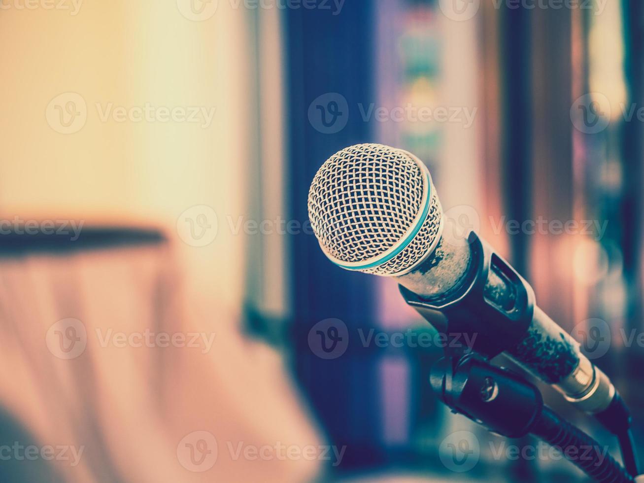 primer plano del micrófono sobre un fondo borroso abstracto para hablar en la sala de seminarios o en la sala de conferencias de comunicación y oratoria, concepto de fondo. foto