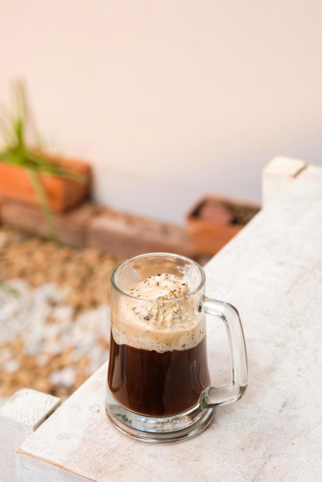 café affogato con helado en una taza de vidrio con fondo de jardín, cóctel de verano foto