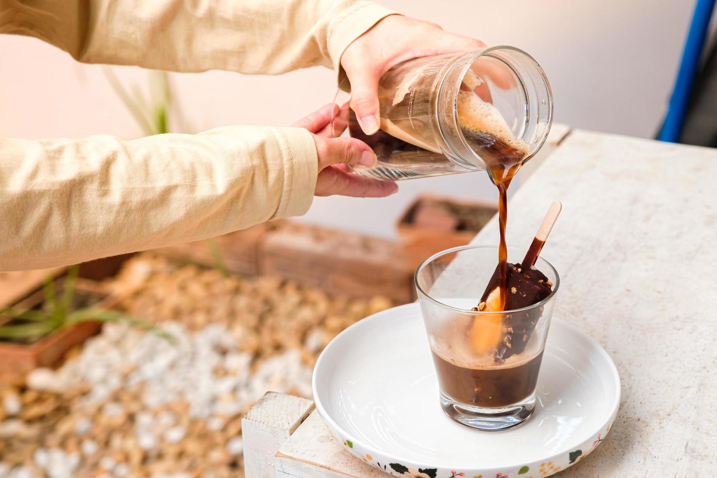 café affogato con helado de chocolate en una taza de vidrio con fondo de jardín, cóctel de verano foto