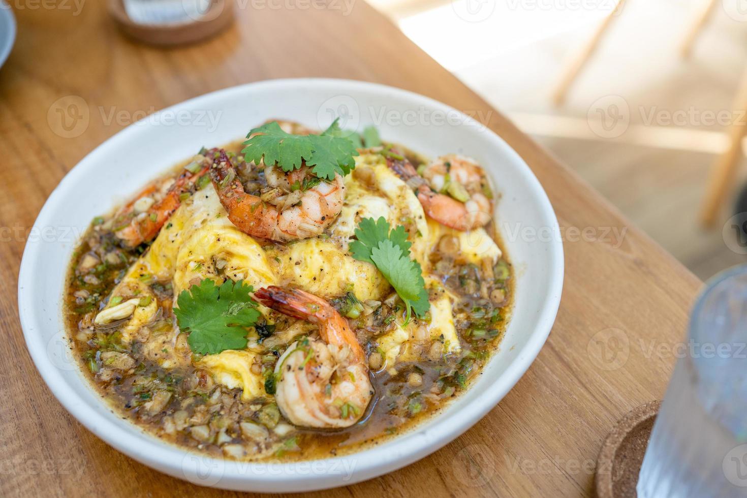 Creamy omelette with shrimps and garlic on rice in wood table. Delicious and easy menu. photo