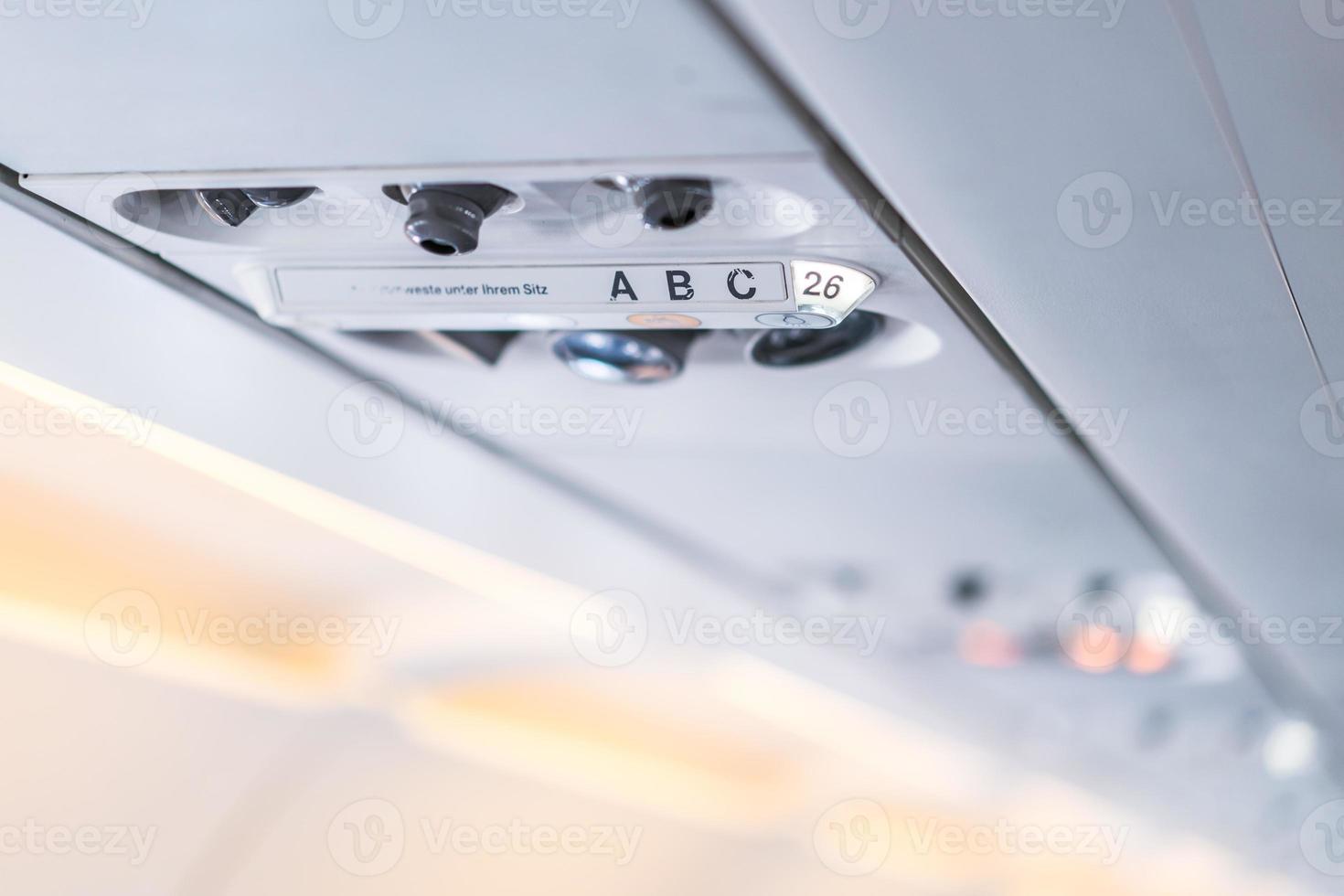 lámpara del panel de la consola del avión de primer plano, luz, botón de ayuda necesaria, aire acondicionado, cinturón de seguridad y señal de iluminación de no fumar. foto
