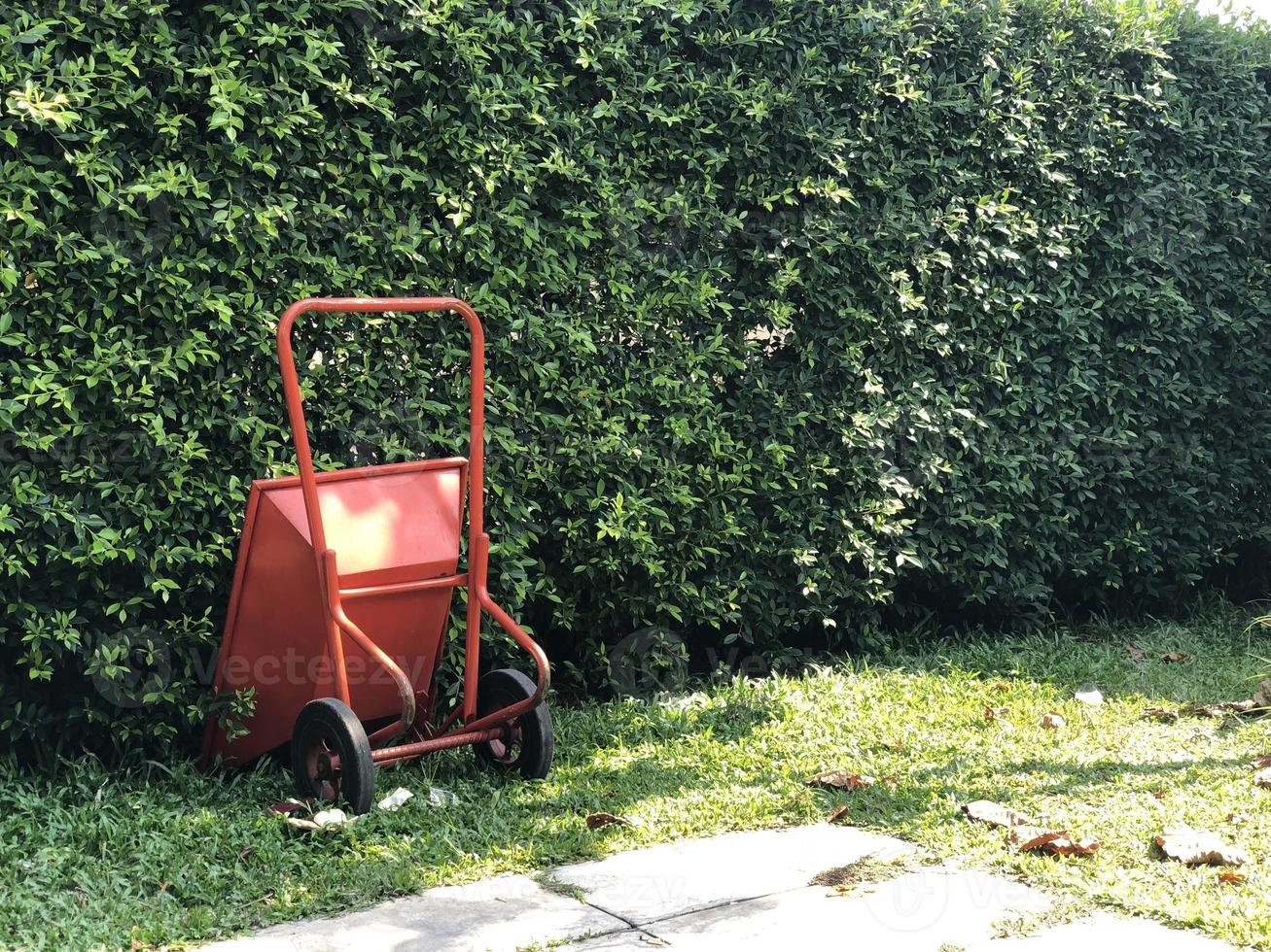 red new Masonry cement cart trolley parking in the garden with tree background. Vintage style. photo