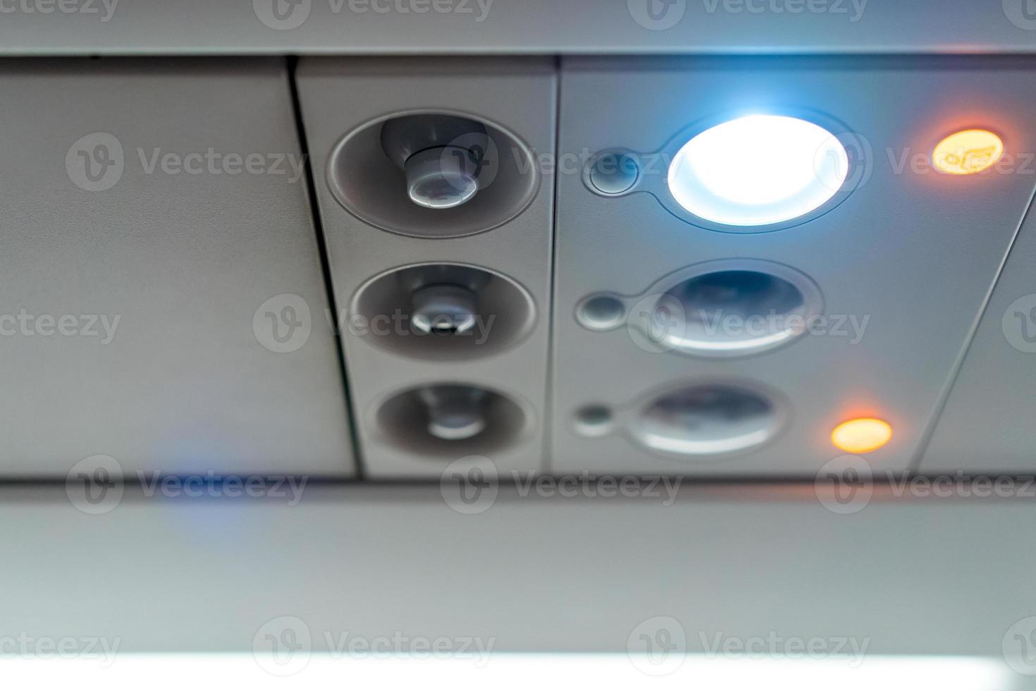 closeup airplane Console panel lamp, light, need help button, air condition, sefty belt and no smoking lighting sign. photo