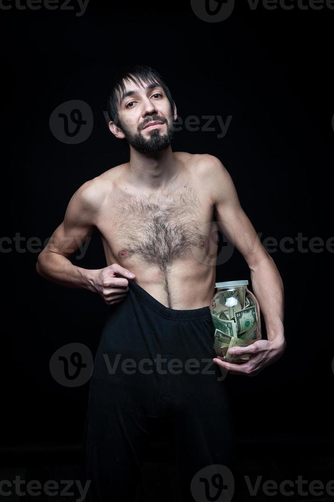 joven con botella de dinero sobre fondo negro foto