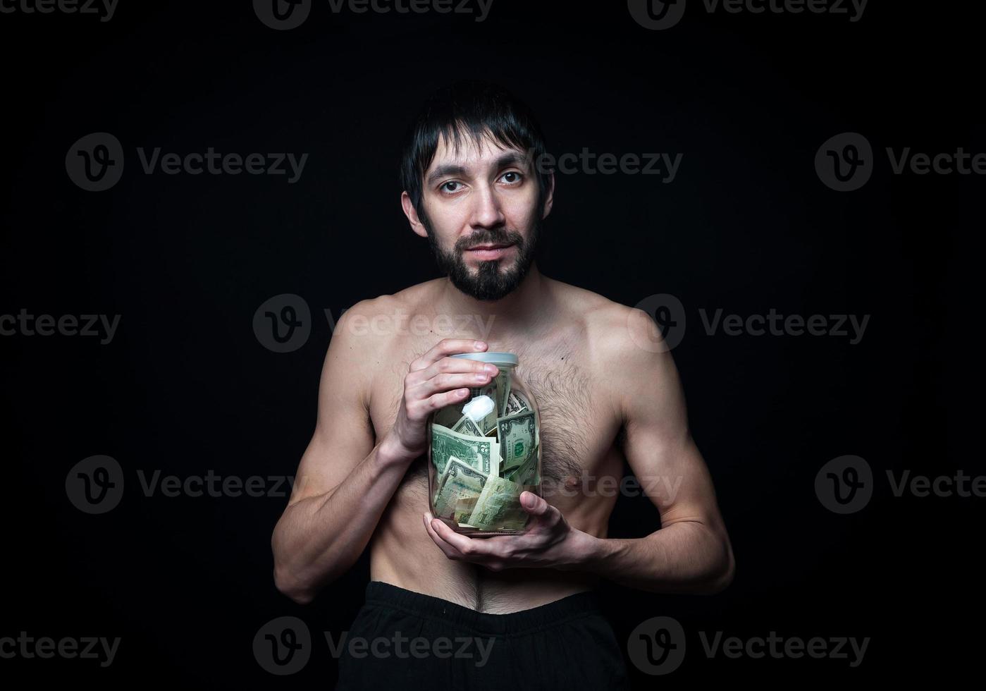 Young man with money bottle on black background photo