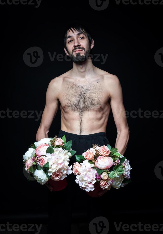 Young man with flowers on black background photo