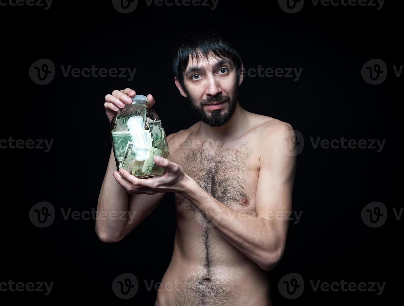 Young man with money bottle on black background photo