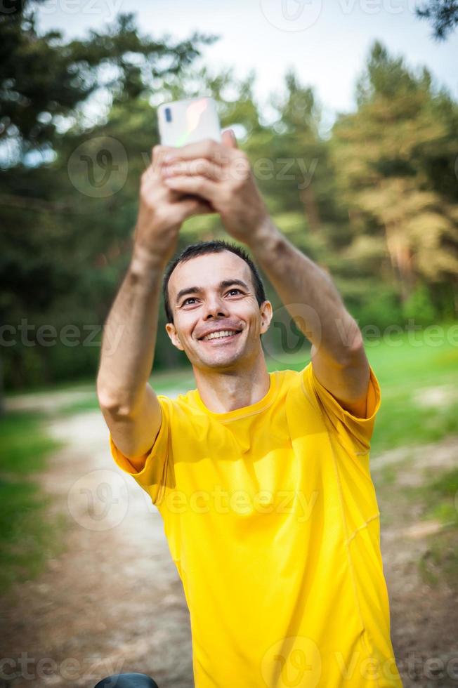 A young man taking a selfie with his Bicycle. photo