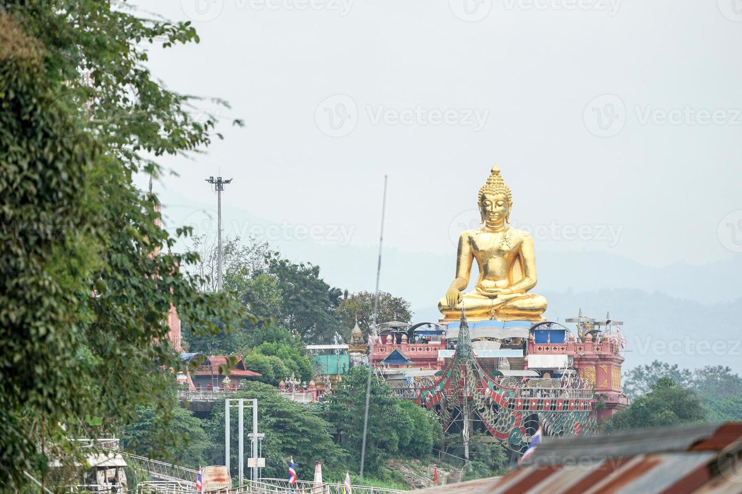 estatua de buda de oro muy grande sentada al lado del río foto