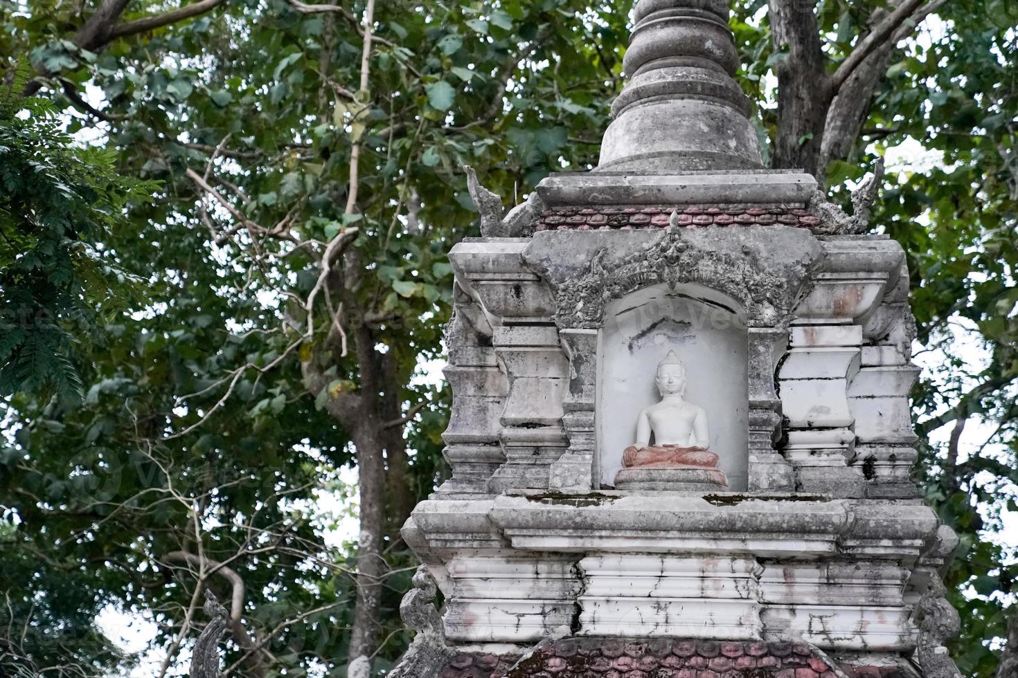 Great white Buddha statue with old background wall. photo