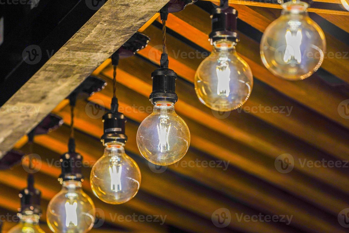 luz de lámpara circular de tungsteno en la fila, pegada en el techo del quiosco de madera. foto